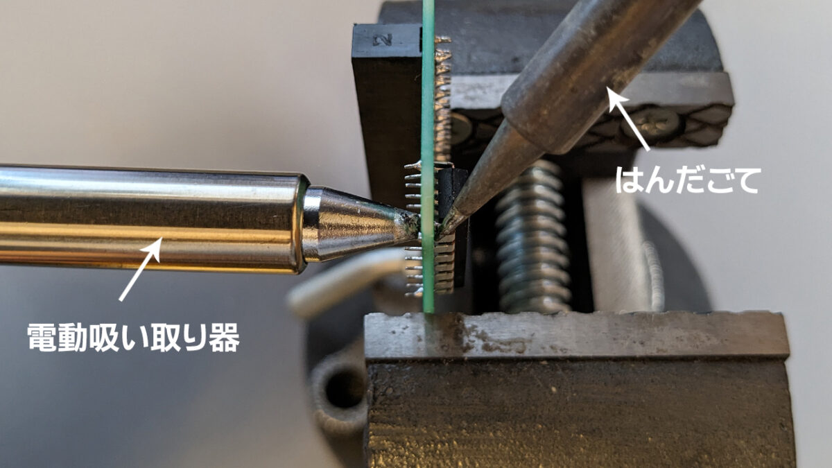 はんだ吸い取り器の先とはんだごての先を基板の両方から当てている様子